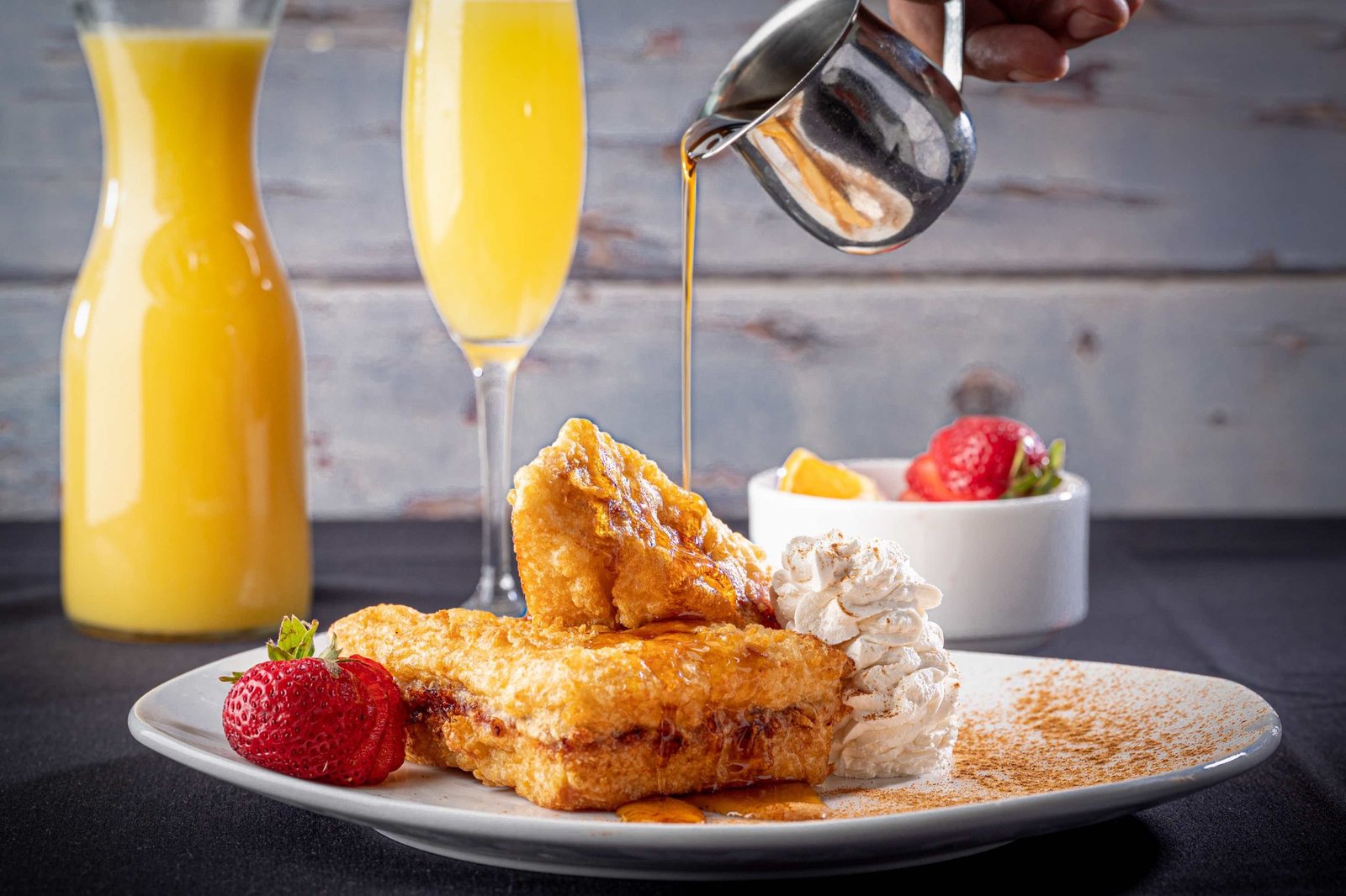 Stuffed French Toast with Fresh Fruit, Syrup, Whipped Cream, Powdered Sugar and a Mimosa.