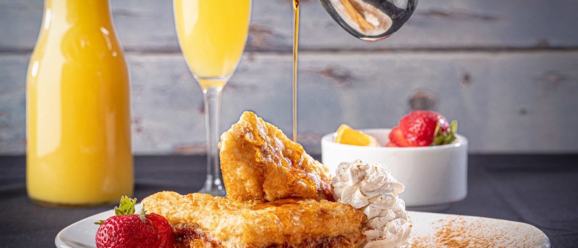 Stuffed French Toast with Fresh Fruit, Syrup, Whipped Cream, Powdered Sugar and a Mimosa.